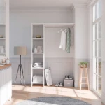 White DELTA wardrobe kit in bright bedroom with shelves, hanging rail and organized storage space.